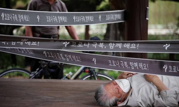 Man rests in an isolated pavilion in a park in Seoul, South Korea, as a measure to prevent the spread of COVID-19