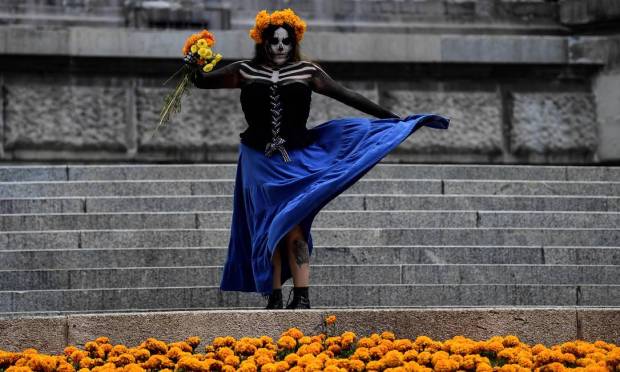 The Catrina woman's costume is photographed alongside Aztec velor motifs along Paseo de la Reforma, in preparation for the Day of the Dead celebration in Mexico City. Photo: PEDRO PARDO / AFP