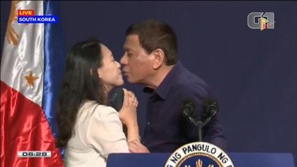 Duterte kisses an employee during an event in South Korea