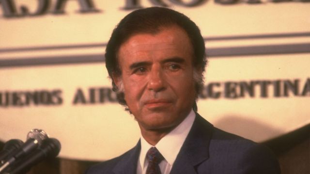 Carlos Menem is a tanned middle-aged man with dyed brown hair