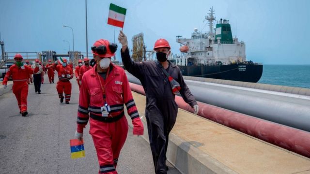 Venezuelan oil workers carry flags of Iran and Venezuela
