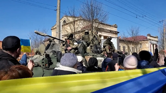 Pro-Ukrainian activists in front of Russian soldiers during a demonstration in Kherson