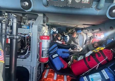 Rescue workers in the Gulf of Mexico receive first aid by helicopter