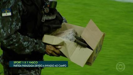 A police officer holds a stone thrown in the field at Ilha do Retiro