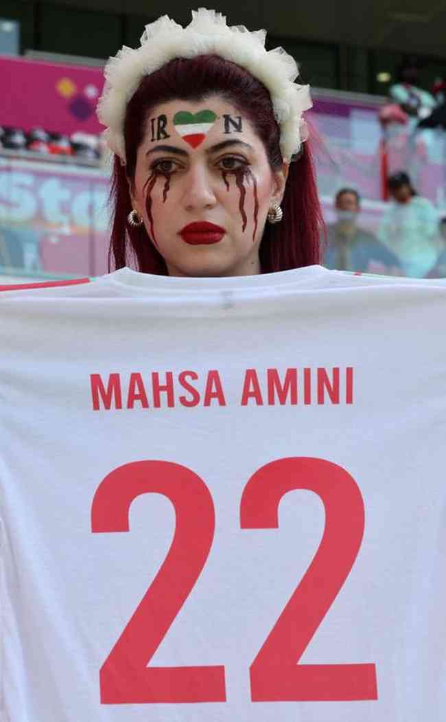 Pictures capture the moment he wears a T-shirt and banner protesting the death of Mahsa Amini