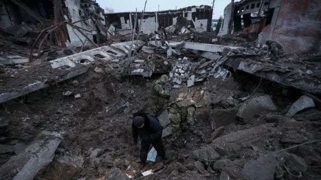 Police and investigators inspect a crater in an industrial area destroyed by a Russian missile strike, amid a Russian attack on Ukraine, in Kharkiv, Ukraine, December 15, 2022.